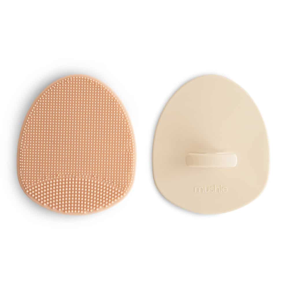 Mushie Baby Bath/Cradle Cap Brush set in blush and shifting sand with textured surface for gentle cleaning.