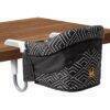 Momcozy Portable High Chair in black with white geometric pattern, designed to attach securely to tables.