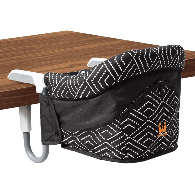 Momcozy Portable High Chair in black with white geometric pattern, designed to attach securely to tables.