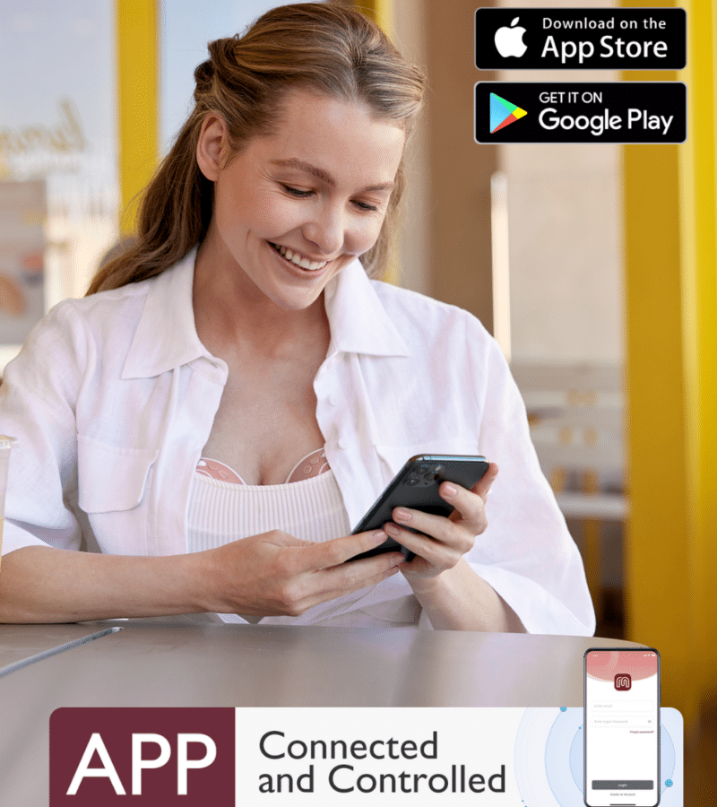 Momcozy Wearable Hands Free Mobile Flow Breast Pump M9 in use by a smiling woman, checking her phone while sitting at a café.