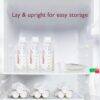 Momcozy Disposable Baby Bottle Kit stored in a refrigerator, featuring clear bottles and milk storage bags for easy access.