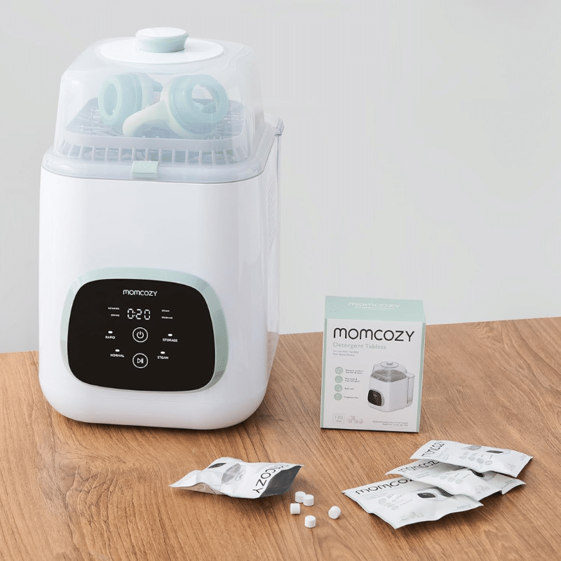 Momcozy Washing Block for KleanPal Pro, includes 120 detergent tablets, shown with the washer and packaging on a wooden