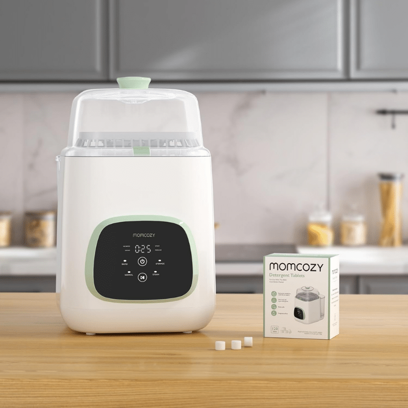 Momcozy Washing Block for KleanPal Pro, 120 detergent tablets, displayed next to the washer on a kitchen countertop.
