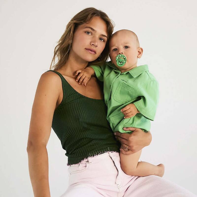 BIBS Studio Polka Pacifier 2 Pack in Ivory/Black and Petal/Cactus, held by a woman and child in a casual setting.