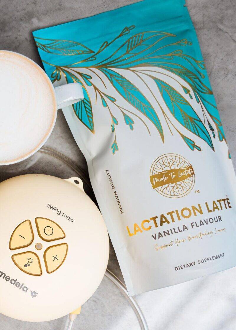 Made to Lactate Lactation Vanilla Latté package next to a cup, featuring a floral design and a Medela breast pump.