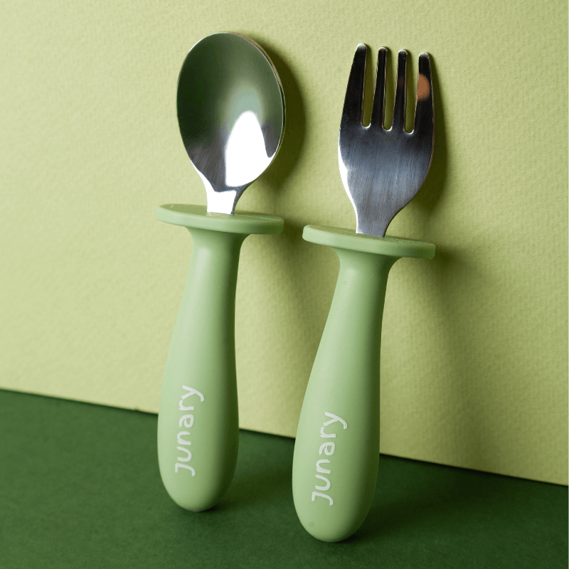 Junary Little Bites Cutlery Duo in green, featuring a spoon and fork with ergonomic handles for easy grip.