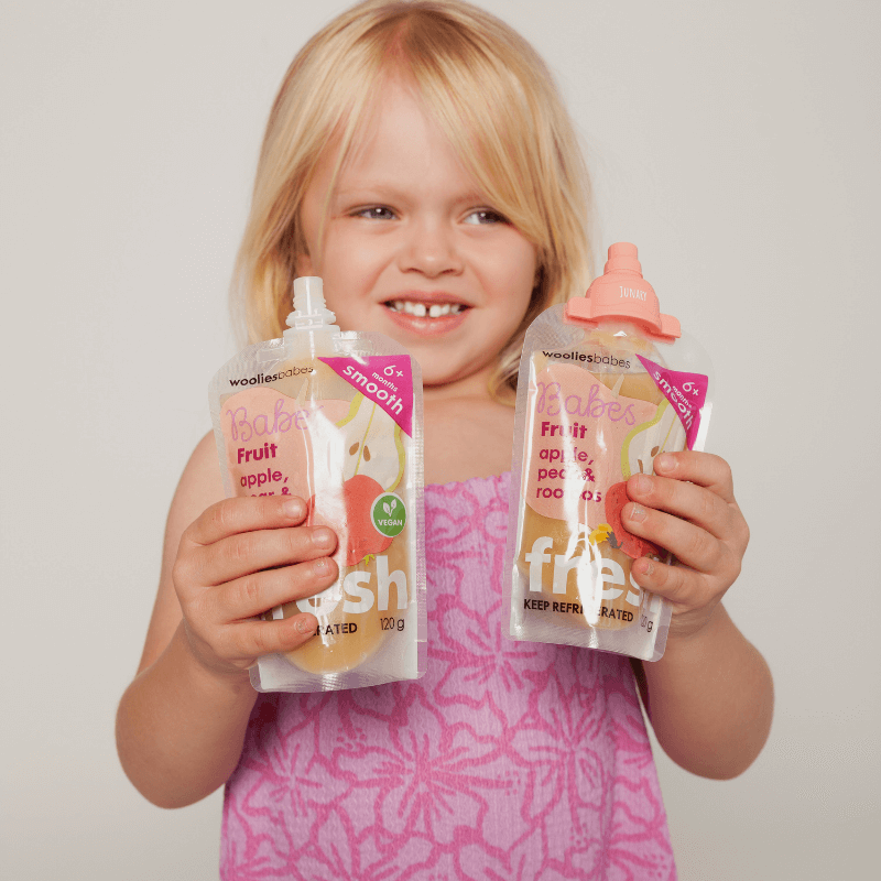 Junary Tiny Toppers Duo featuring two colorful fruit puree pouches held by a smiling child in a pink outfit.