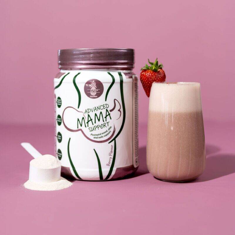 SoFitt™ Advanced Mama Support powder next to a glass of creamy smoothie and fresh strawberry on a pink background.