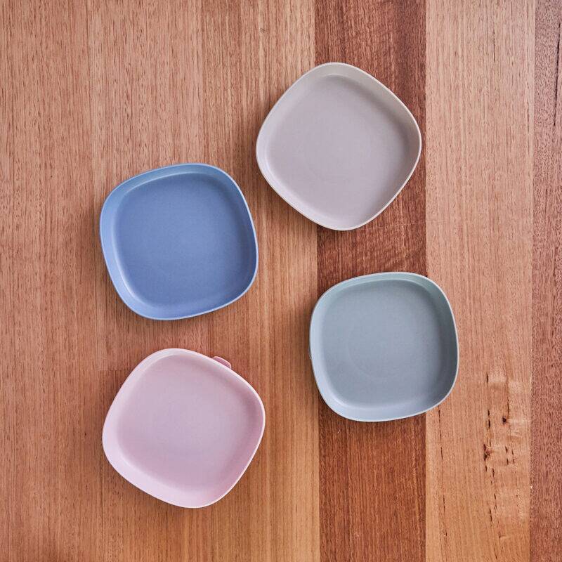 b.box silicone plates in blush and ocean colors, featuring a modern square design, arranged on a wooden surface.