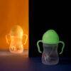 b.box Sippy Cup in Glow in the Dark, featuring ergonomic handles and a soft spout, illuminated against a dark background.