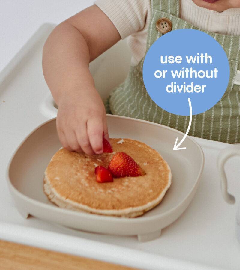 b.box silicone plate in blush with a child reaching for a pancake topped with strawberries, showcasing its flexible use.