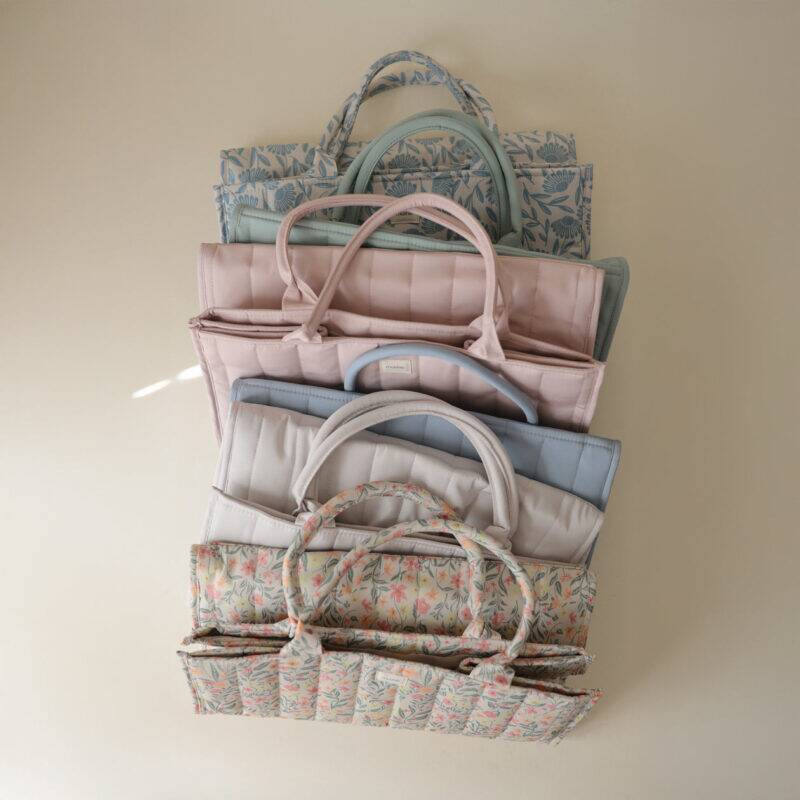 Mushie Diaper Caddy in blue flowers and blush, stacked to show various colors and patterns.