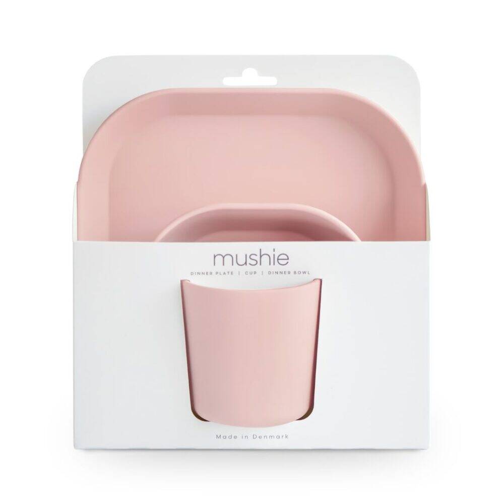 Mushie dinnerware set in blush, featuring a dinner plate, cup, and bowl in a stylish packaging.