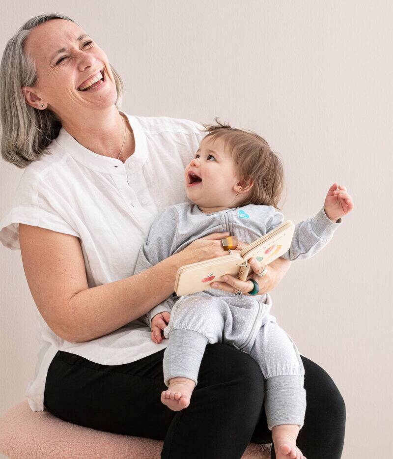 Love To Dream Sleep Suit Long Sleeve 1.0 Tog in white, worn by a baby held by a smiling adult, both enjoying a playful