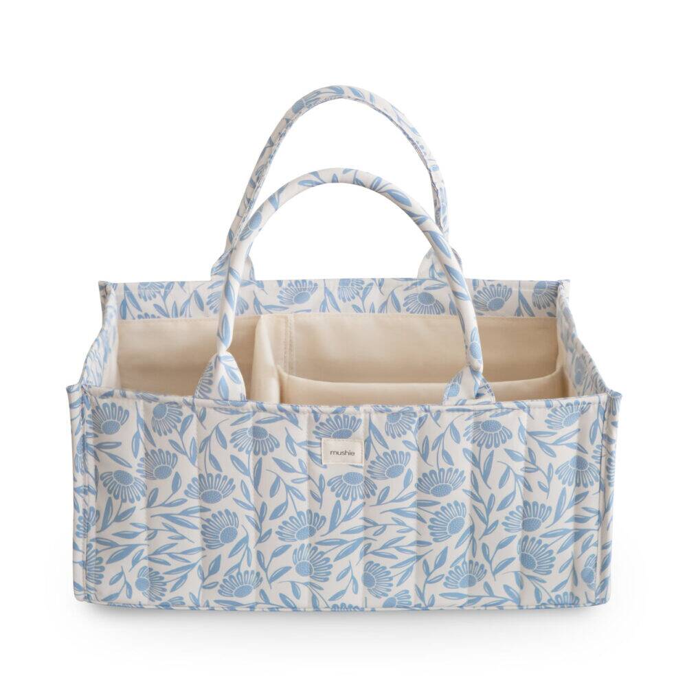 Mushie Diaper Caddy in Blue Flowers and Blush with multiple compartments and sturdy handles for easy carrying.