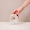 Difrax Handsfree Breastpump with a clear design, held by a hand, showcasing its ergonomic shape and functionality.