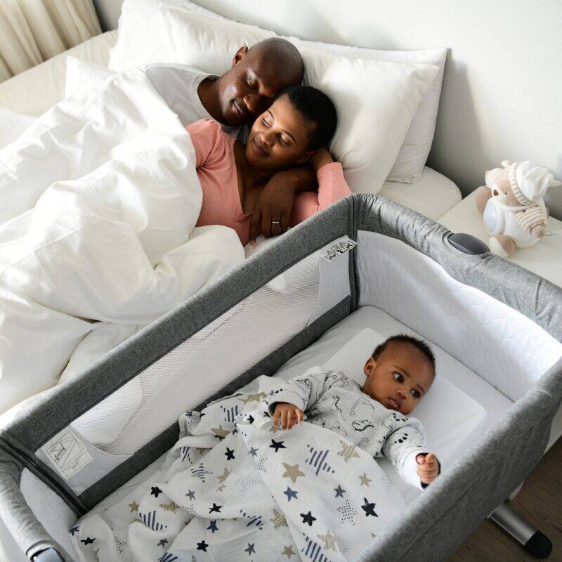 Snuggletime Deluxe Muslin Receiver in blue stripe and pink blossoms, featuring a sleeping baby beside parents in a cozy