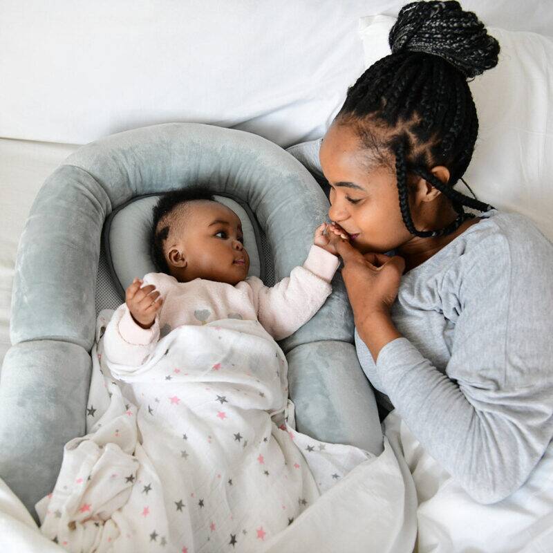 Snuggletime Bamboo Muslin Receiver in blue star, featuring a baby and mother sharing a tender moment in a cozy setting.