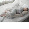 Snuggletime Body Comfort Pillow in taupe, designed for support, shown in a cozy bedroom setting with a woman sleeping.