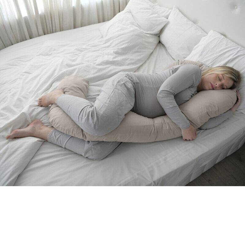 Snuggletime Body Comfort Pillow in taupe, designed for support, shown in a cozy bedroom setting with a woman sleeping.