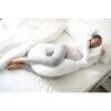 Snuggletime Body Comfort Pillow in grey and white, featuring a curved design, used by a person relaxing on a bed.