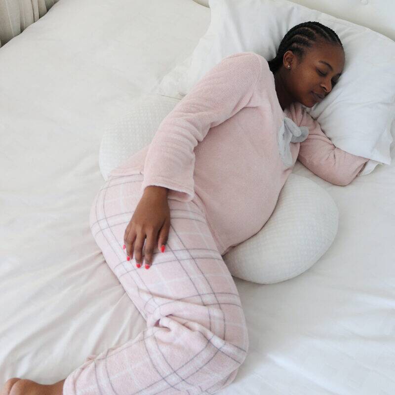 Snuggletime Bamboo Dual Support Preggy Wedge in use, supporting a pregnant woman in cozy pajamas while she sleeps.