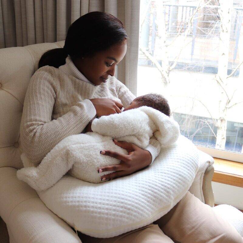 Snuggletime Bamboo Snuggle Up Pillow in white, cradling a parent and baby in a cozy indoor setting.