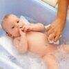 Snuggletime Baby Bather in blue, featuring a baby comfortably lying in a bath with bubbles, being gently washed.