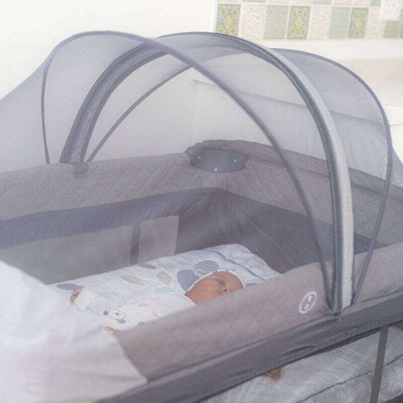 Snuggletime Dome Mosquito Protection Netting in grey, covering a baby in a portable crib, providing a safe sleeping