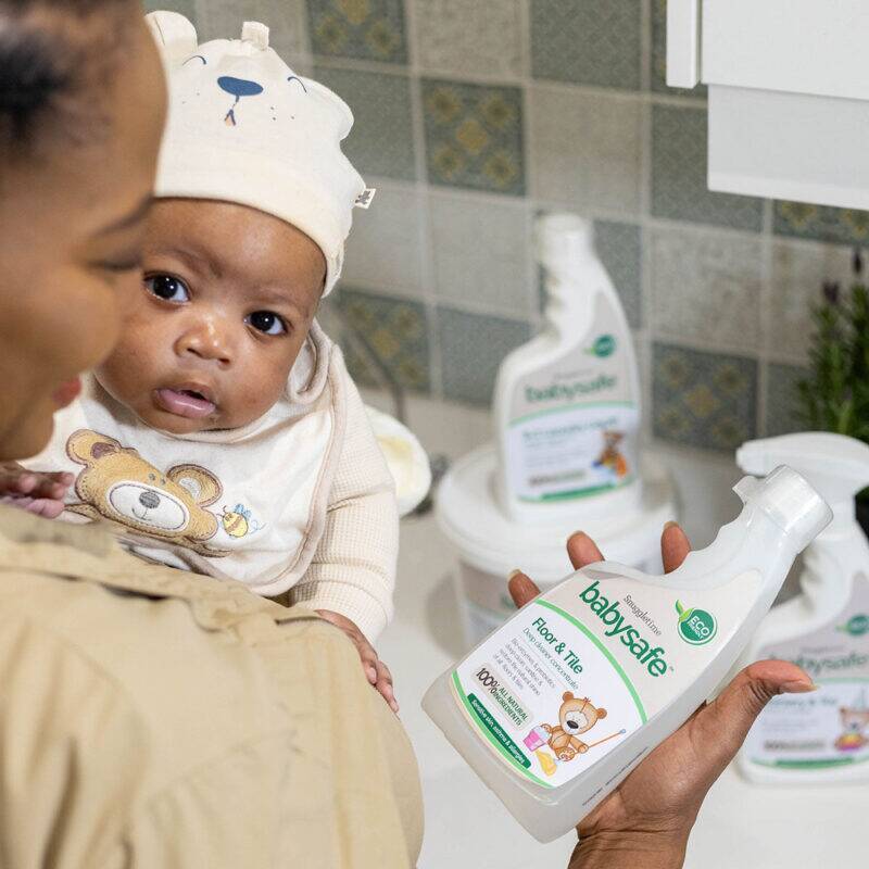 BabySafe Floor & Tile Deep Cleaner Concentrate held by a caregiver with a baby, showcasing a safe cleaning environment.