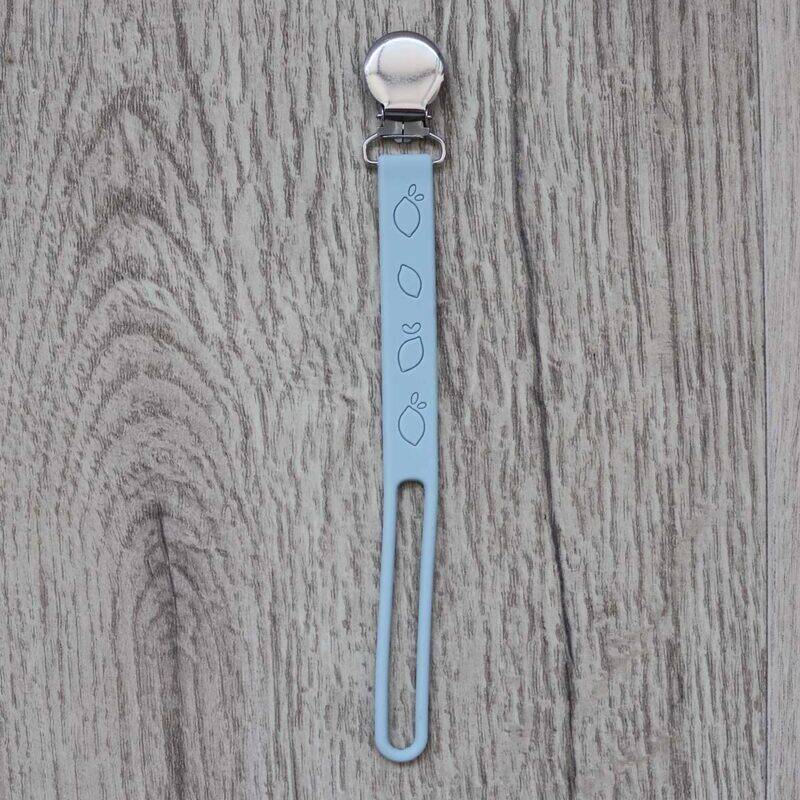 Back To Nature Silicone Pacifier Clip in light blue with a secure metal clip and playful design, set against a wooden