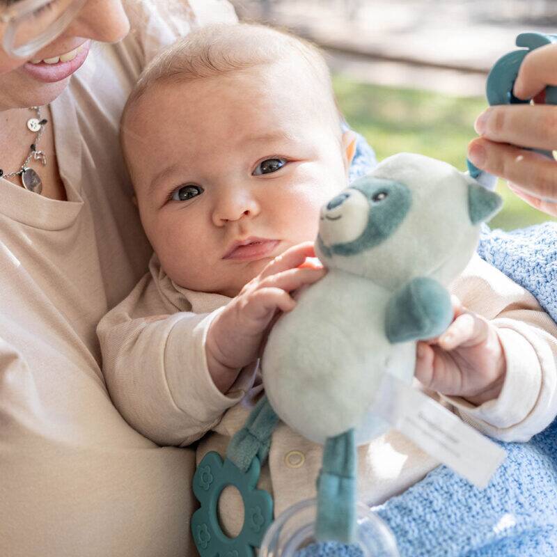 Back To Nature Wiggle & Giggle Pals in blue and pink, featuring a baby holding the plush toy while being cuddled.