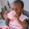 Back to Nature 5pc Character Silicone Feeding Set in pink with rainbow design, featuring a child drinking from a cup.