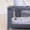 Snuggletime Classic Comfort Camp Cot in gray, featuring a mesh side for visibility, with a baby peacefully resting inside.
