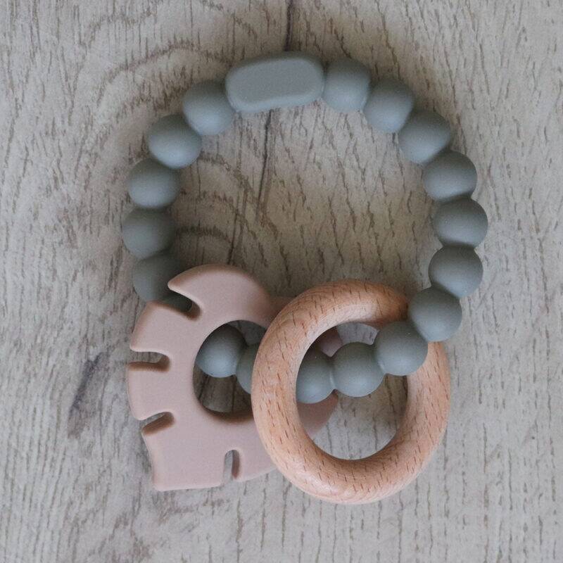 Back to Nature Silicone Teether Leaf in muted green and pink, featuring a wooden ring for added texture and grip.