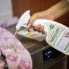 BabySafe Laundry Stain Remover spray bottle being used on a pink towel near a washing machine.