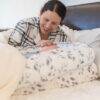 Snuggletime Deluxe Comfort Pod with Activity Arch in a cozy bedroom, featuring a mother interacting with her baby.