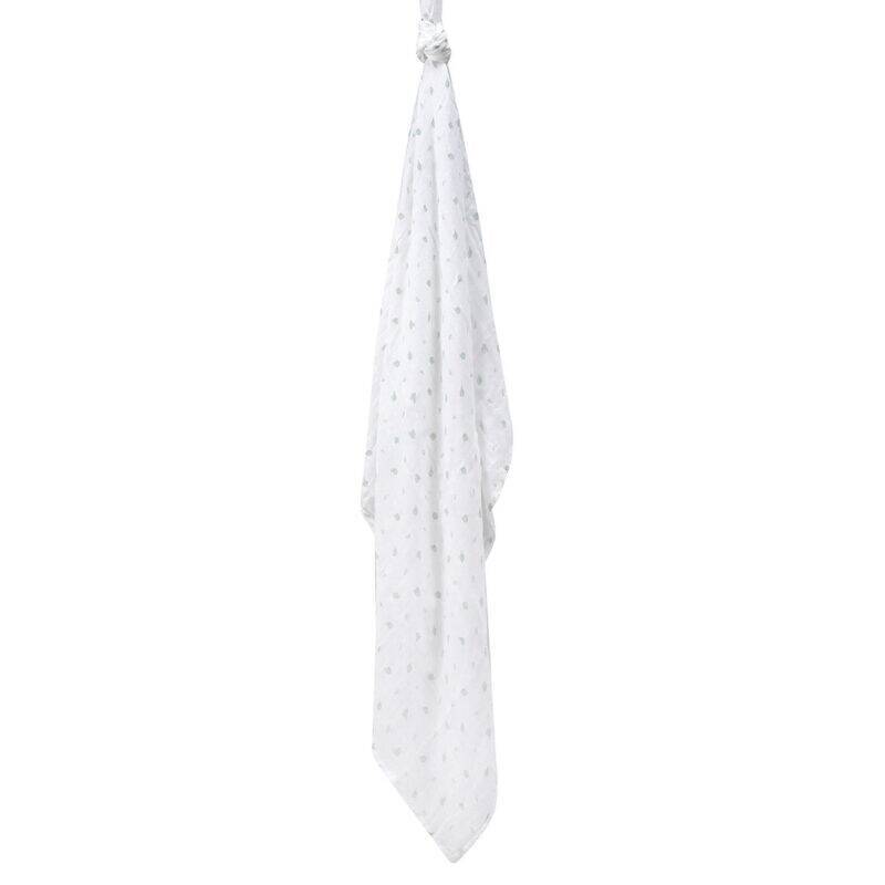Infancie Bamboo Muslin Blanket in white with green leaf patterns, hanging to showcase its lightweight and breathable fabric.