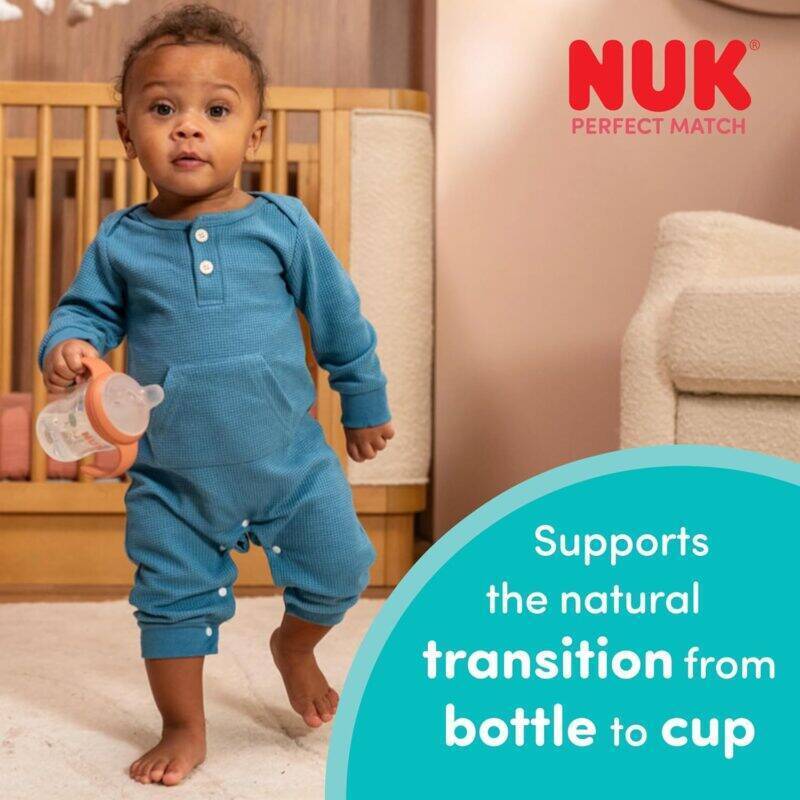 Nuk Perfect Match Learner Bottle 150ml in Rainbow Sheep style, held by a toddler in a cozy playroom setting.