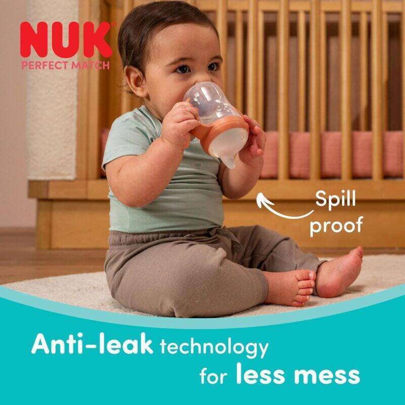 Nuk Perfect Match Learner Bottle 150ml in Rainbow Sheep design, featuring anti-leak technology, held by a toddler sitting on