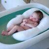Snuggletime Microbead Baby Bather Cushion in blue, gray, and white, featuring a baby comfortably resting in a bath.