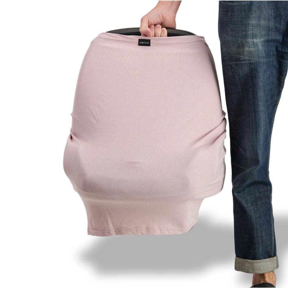 FIB pink stretchy car seat cover being held by a person, designed for easy installation and protection.