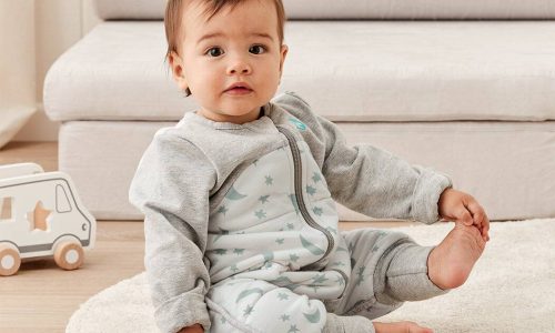 Love to Dream Sleep Suit Long Sleeve 2.5 TOG in Moonlight Dusty, featuring star patterns, worn by a sitting baby on a rug.